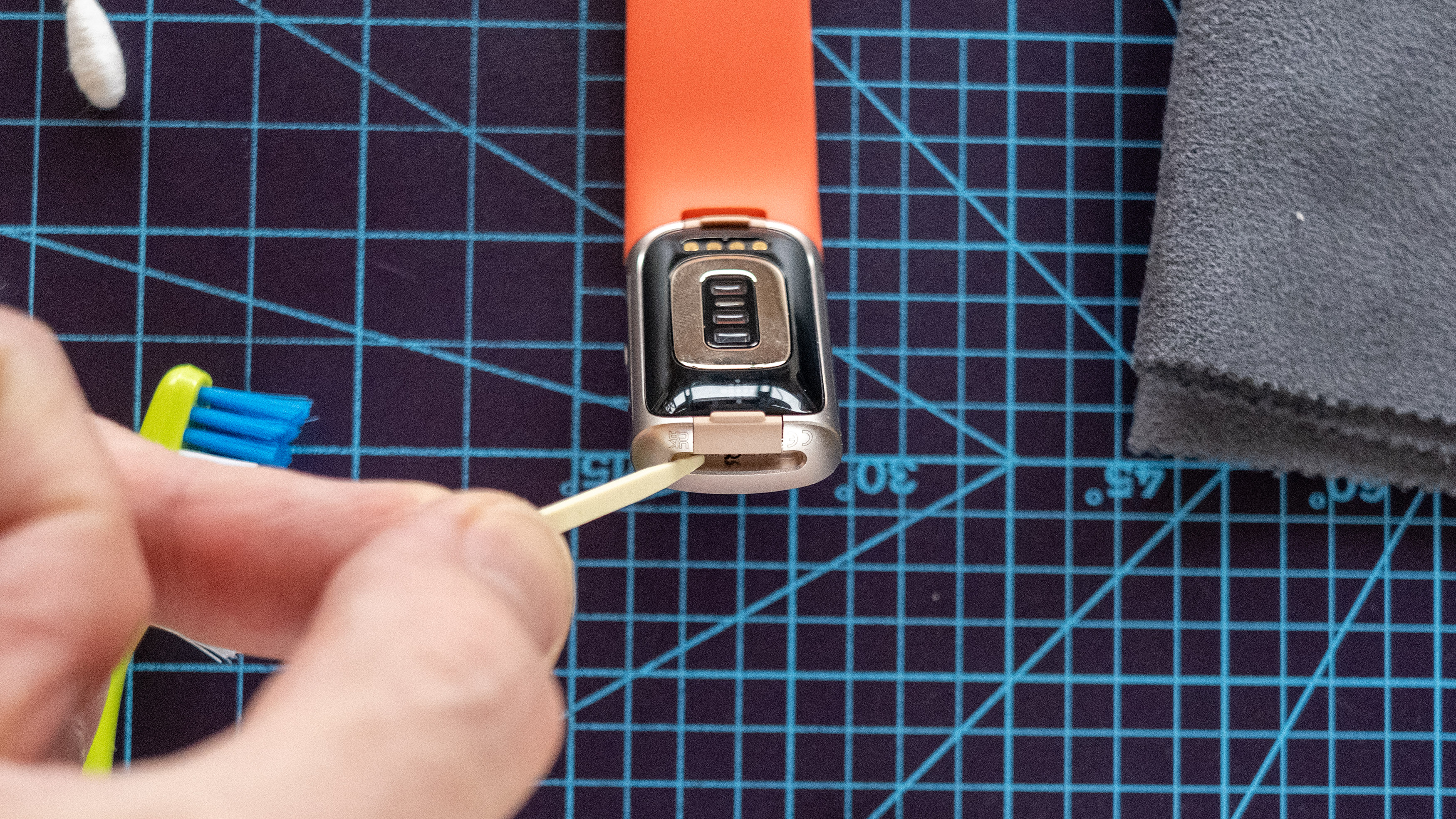 ניקוי הפינות של Fitbit באמצעות קיסם.