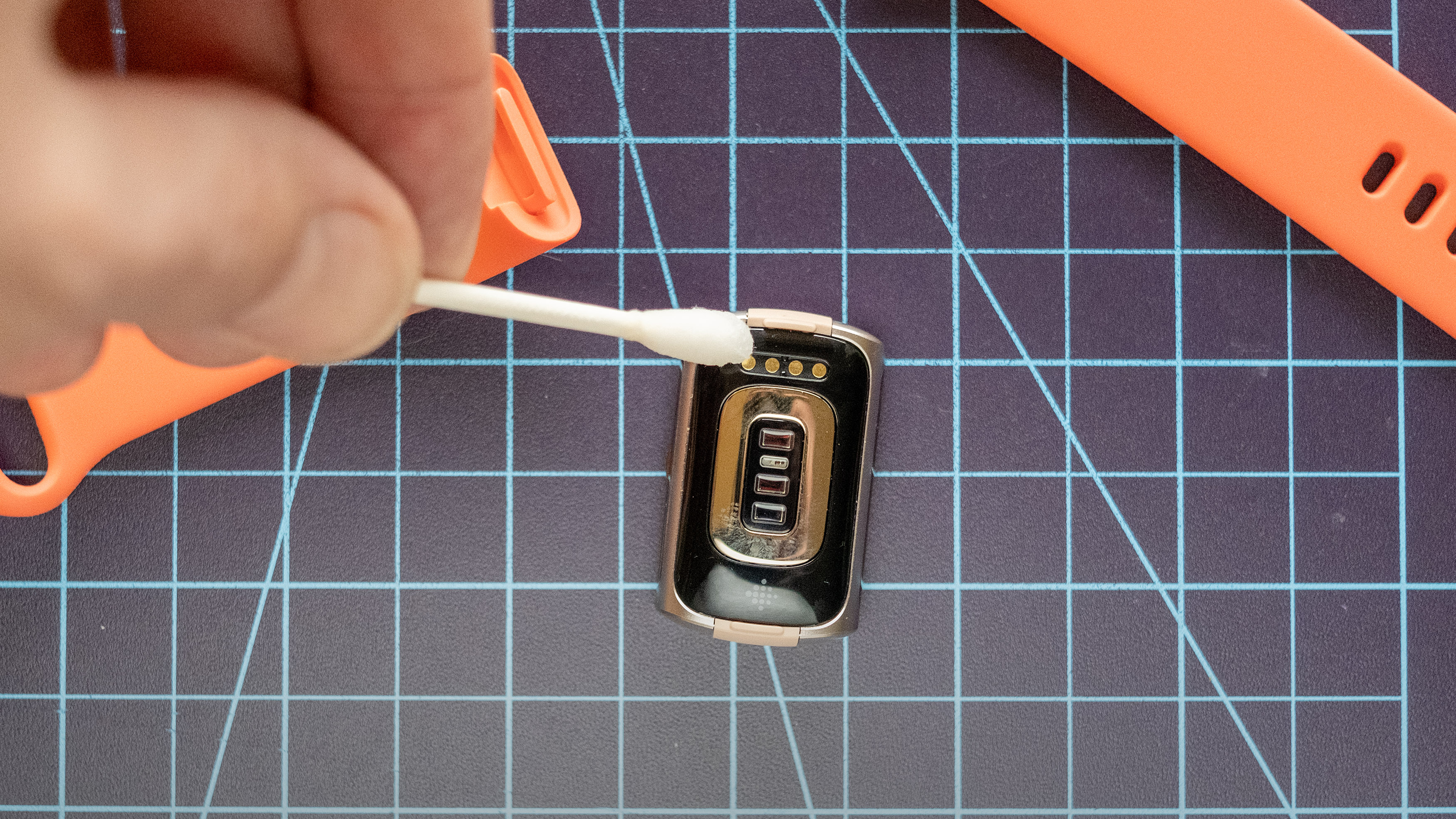 ניקוי המגעים החשמליים ב-Fitbit Charge 6.