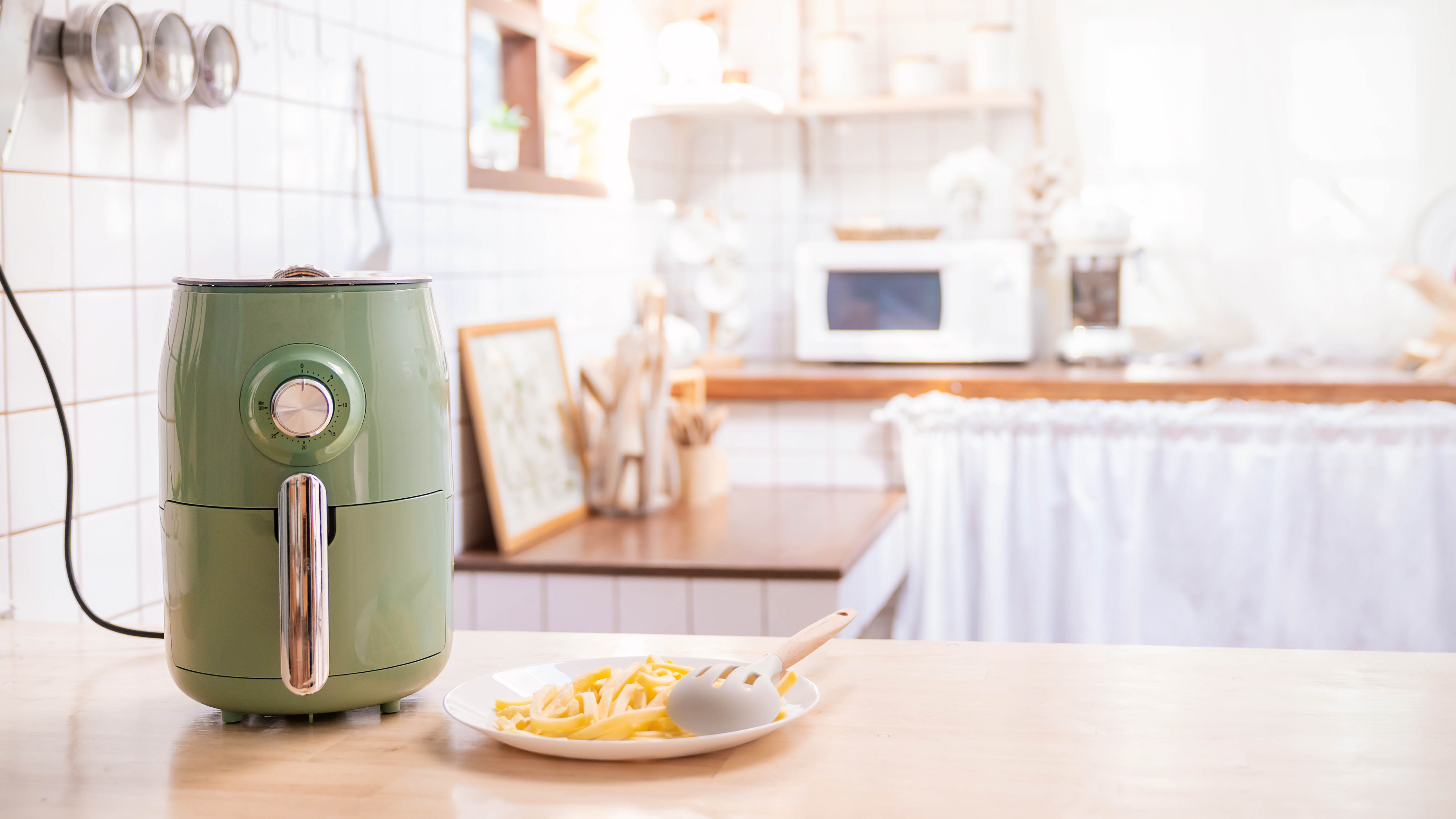 טיגון אוויר ירוק על דלפק פתוח ליד צלחת צ'יפס