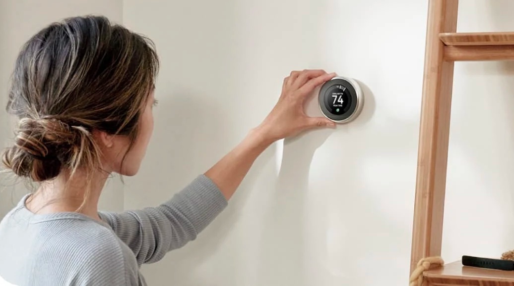 אישה משתמשת ב-Nest Learning Thermostat