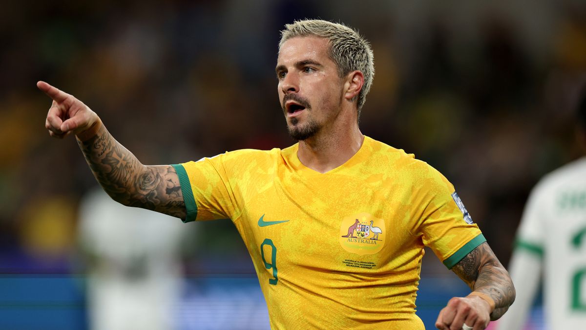 Jamie Maclaren of the Socceroos in yellow shirt points on the pitch ahead of the AFC Asian Cup Australia vs India live stream