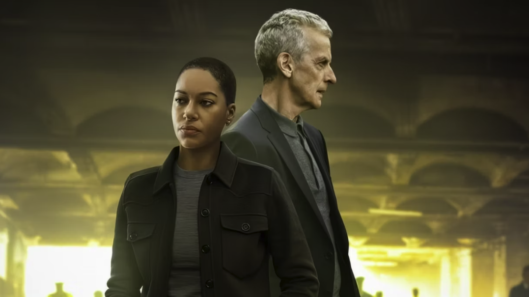Cush Jumbo and Peter Capaldi, both wearing smart, dark outfits, pose in a promotional image for new Apple TV show Criminal Record