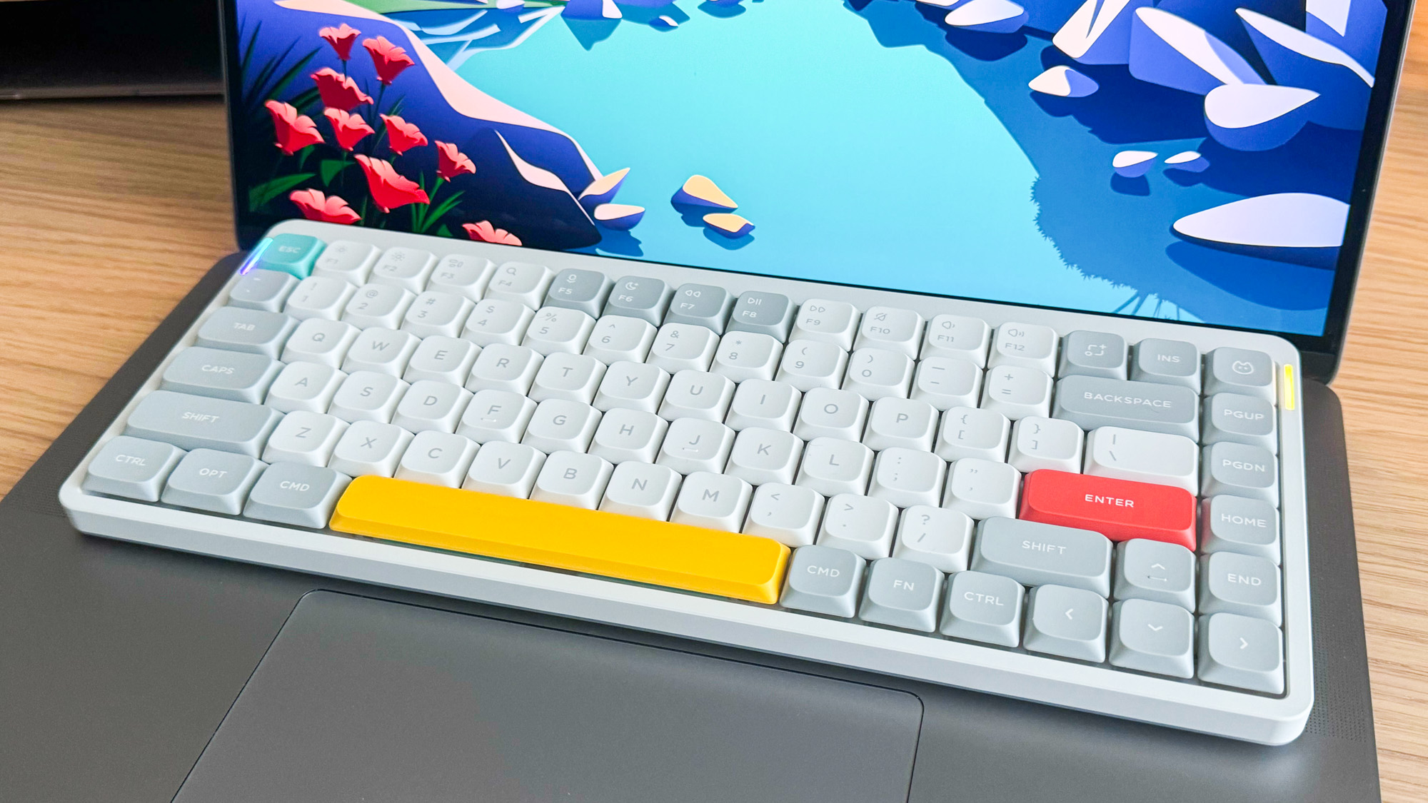 תמונה של NuPhy Air75 V5 ממוקם מעל מקלדת של מחשב נייד.