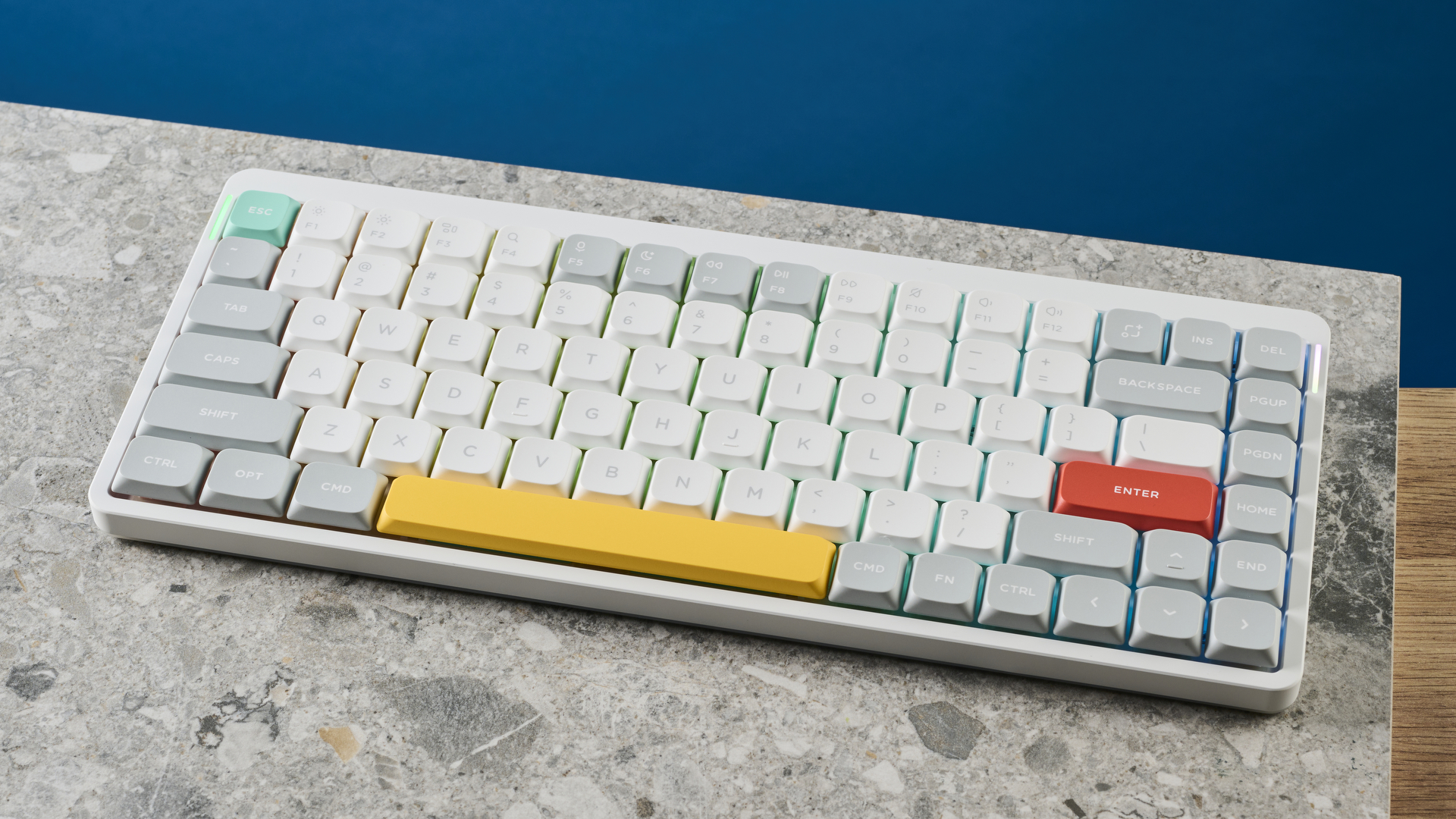 תמונה של ה-NuPhy Air75 V2 על לוח אבן עם קיר כחול ברקע.