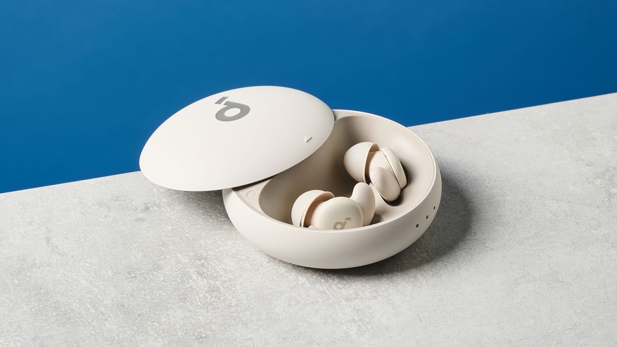 A photo of the Soundcore Sleep A20 earbuds out of and next to their case on a stone surface with a blue wall in the background.