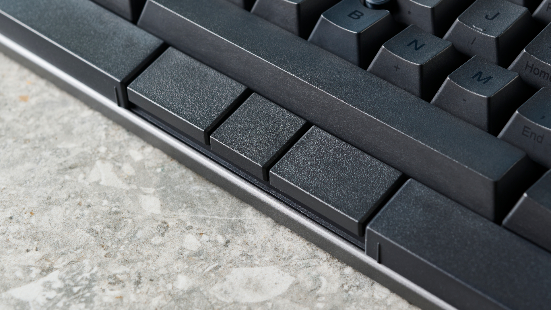 תמונה של המקלדת המכנית HHKB Studio על משטח אבן