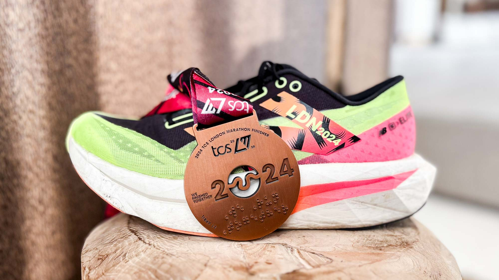 New Balance FuelCell SC Elite v4 London Edition על דוכן ליד תג המסיים במרתון לונדון