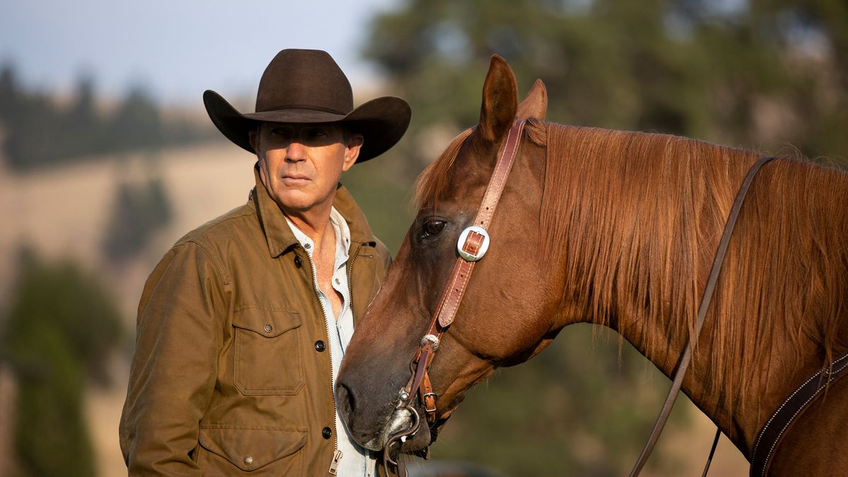 Kevin Costner as John Dutton, next to a horse, in