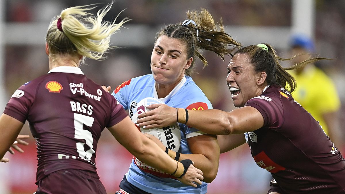 Blues player is tackled by two Maroons in the Women