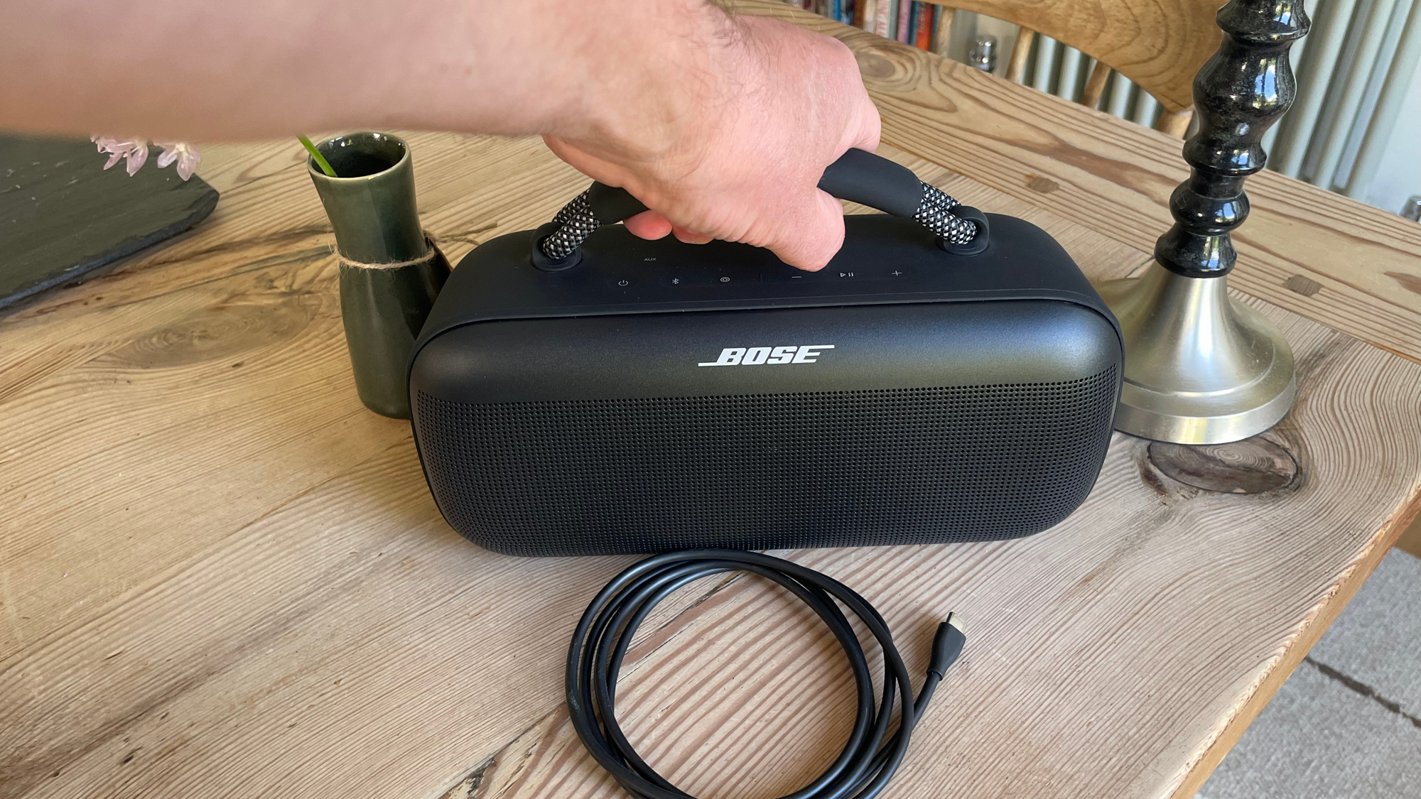 Bose SoundLink Max מוחזק בידית נשיאה מעל שולחן המטבח