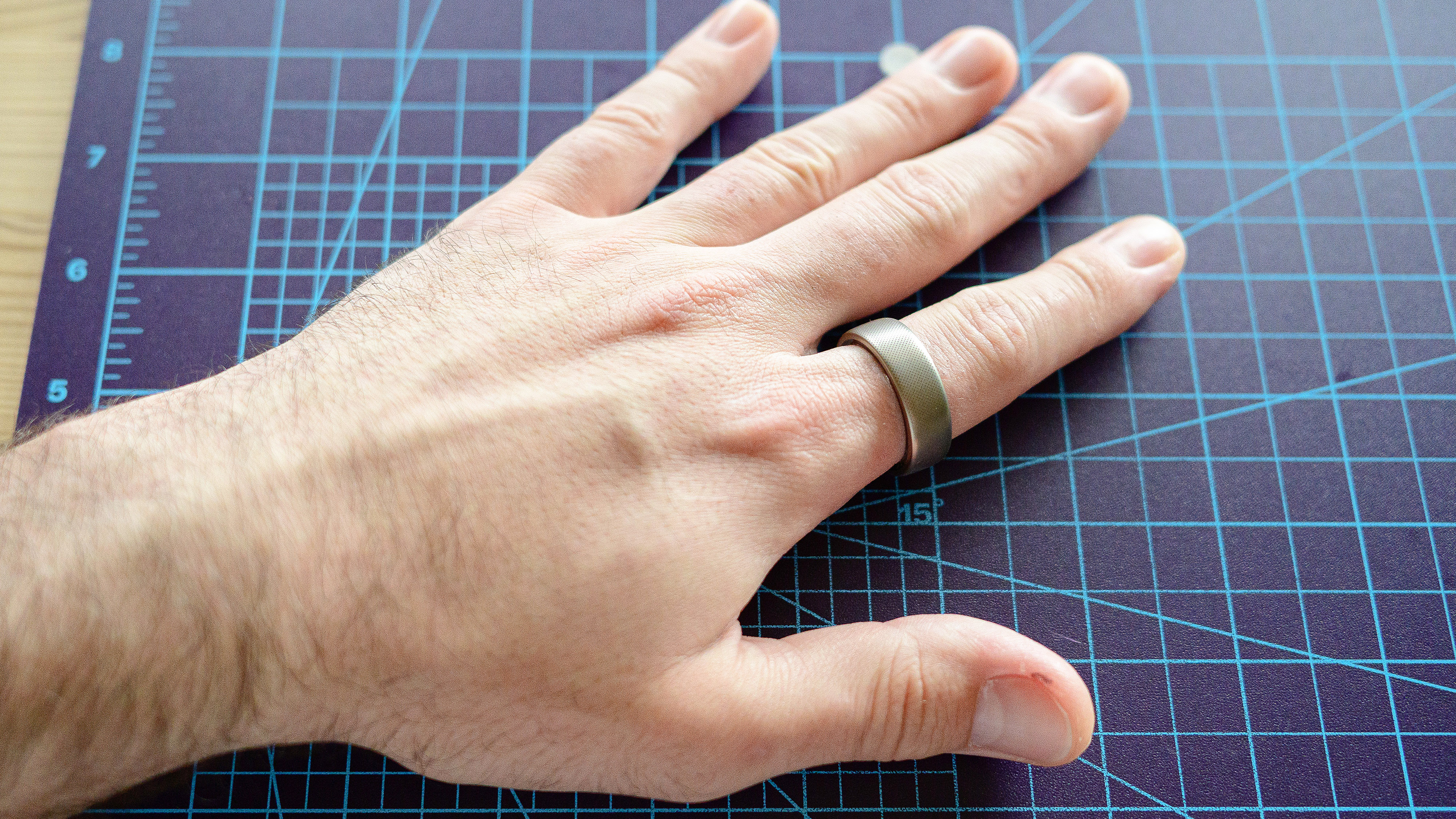 טבעת Amazfit Helio על אצבע של אדם על שולחן