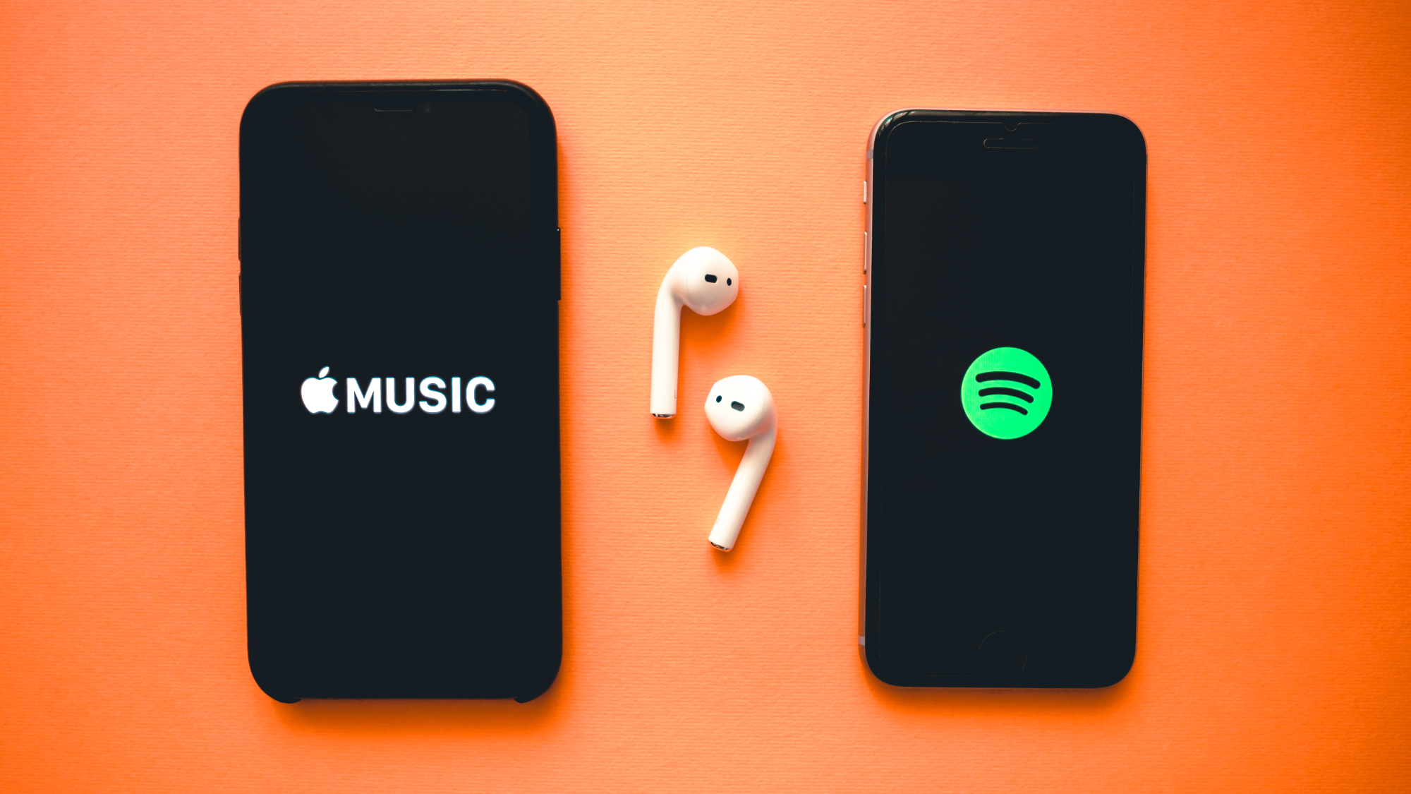 לוגו של Apple Music ו- Spotify בשני מכשירי אייפון