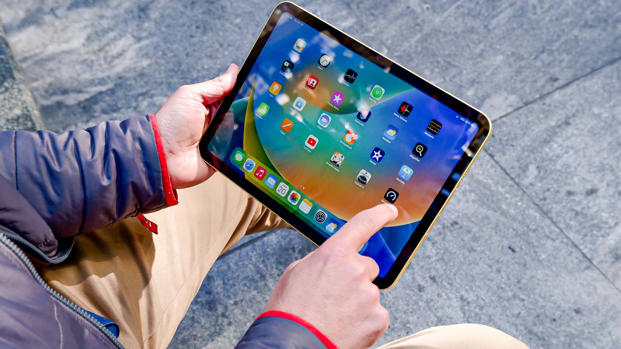 אייפד דור 10 בידיים הגולשות במסך הבית של מערכת ההפעלה iPad
