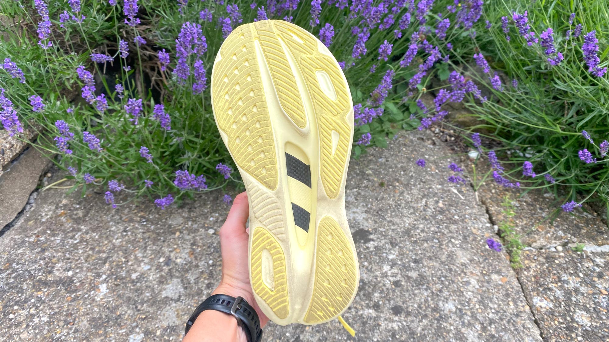 אדם המחזיק את Hoka Skyward X מראה את סוליה החיצונית של הנעל