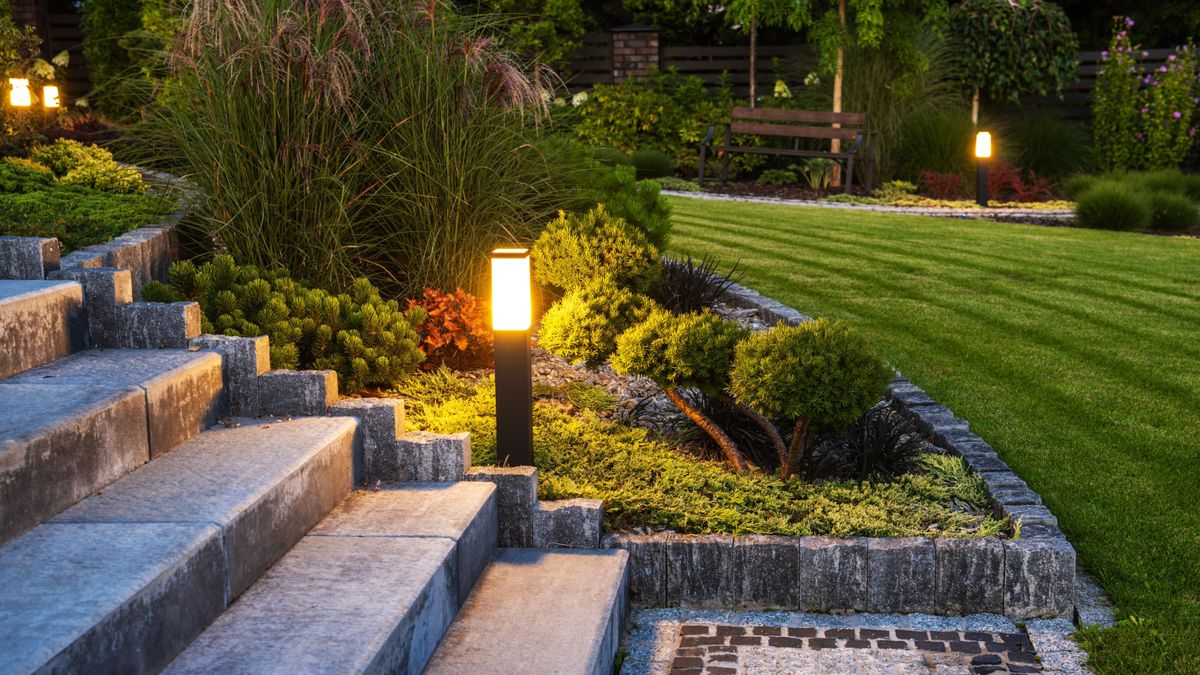 Solar powered light in a manicured garden at dusk