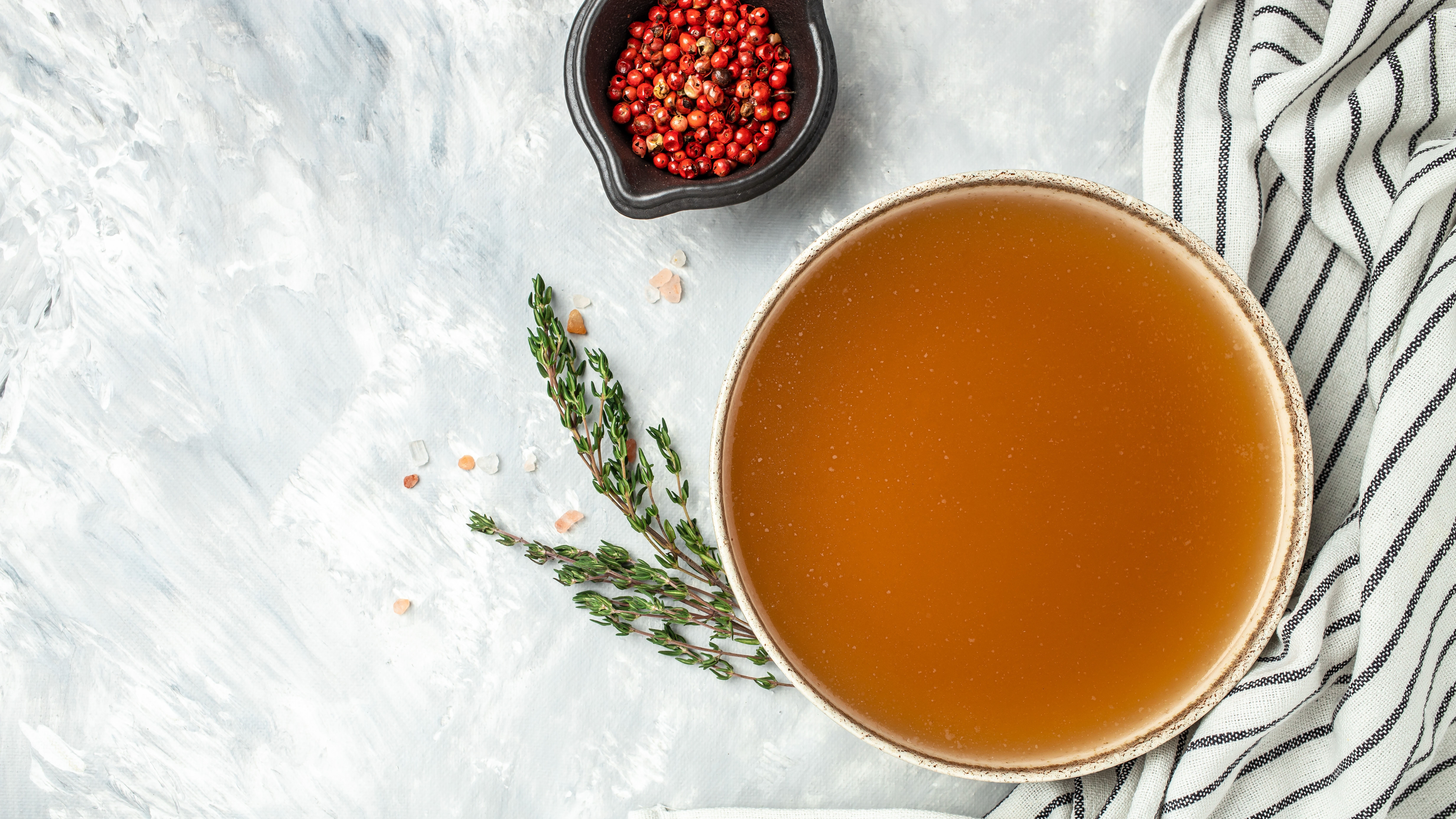 מרק על שולחן שיש ולידו מיכל קטן של פירות יער