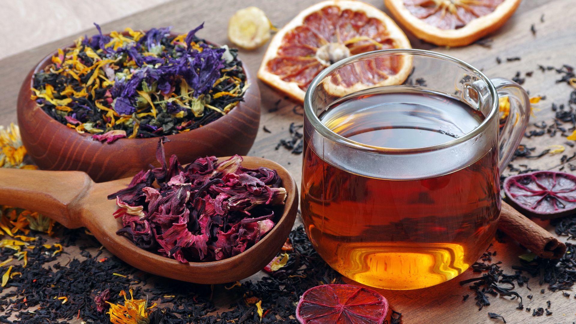 כוס תה צמחים ליד קערת עלי תה