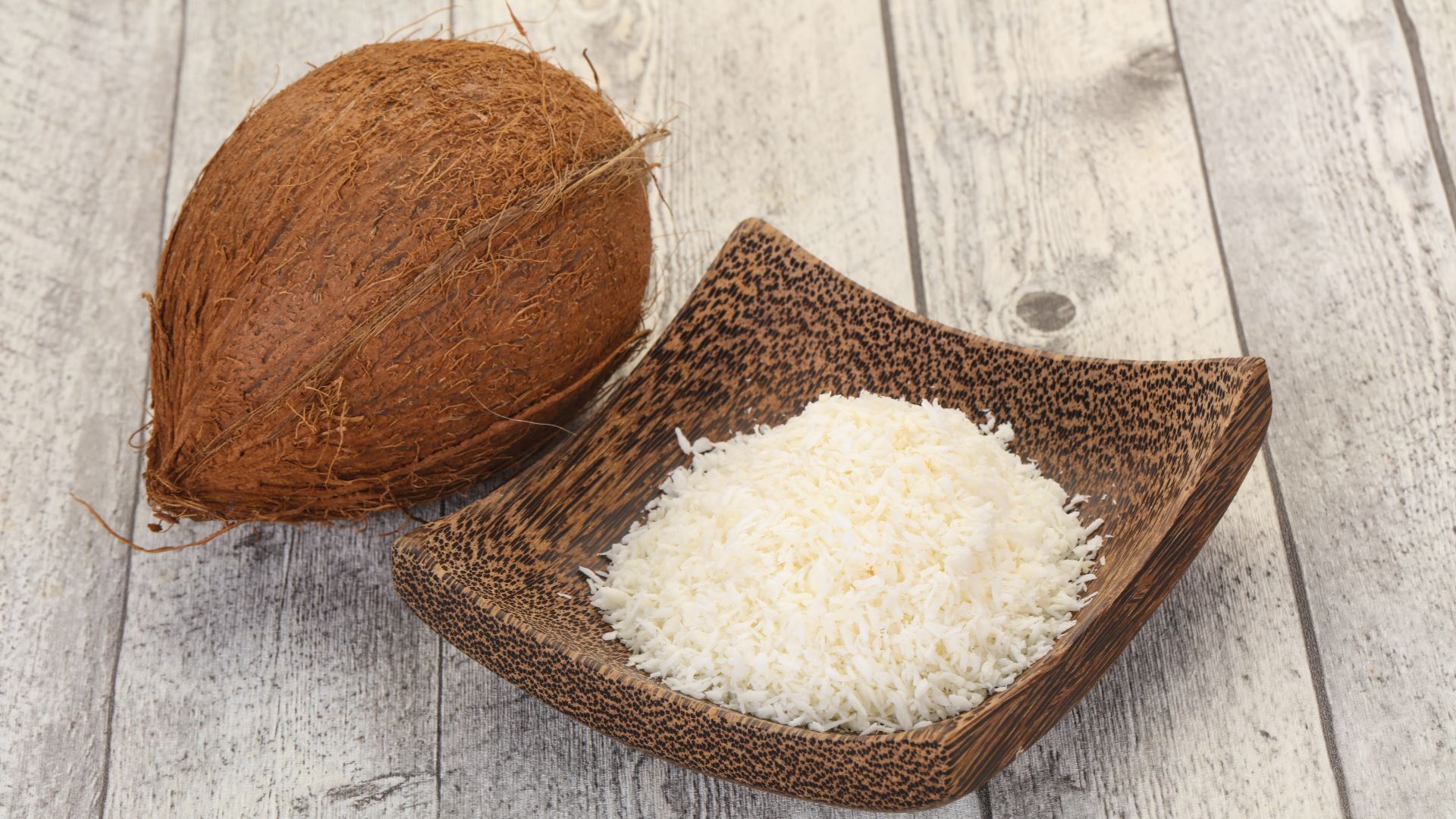 קערת קוקוס מיובש לצד קוקוס טרי