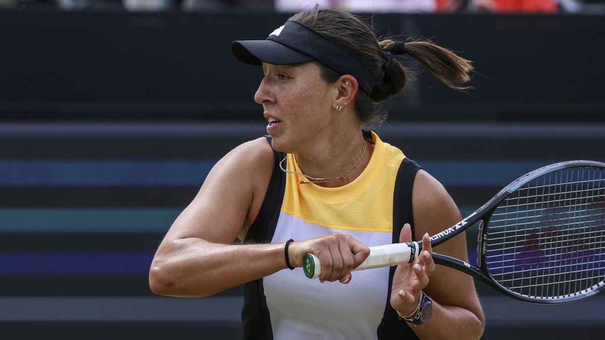Jessica Pegula plays a shot in a yellow, white and black vest