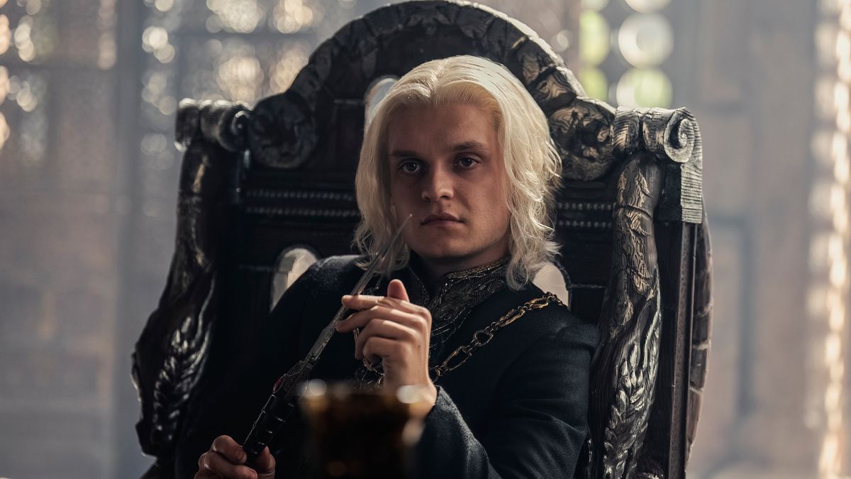 Aegon II (Tom Glynn-Carney) sitting in a chair in the Small Council room in