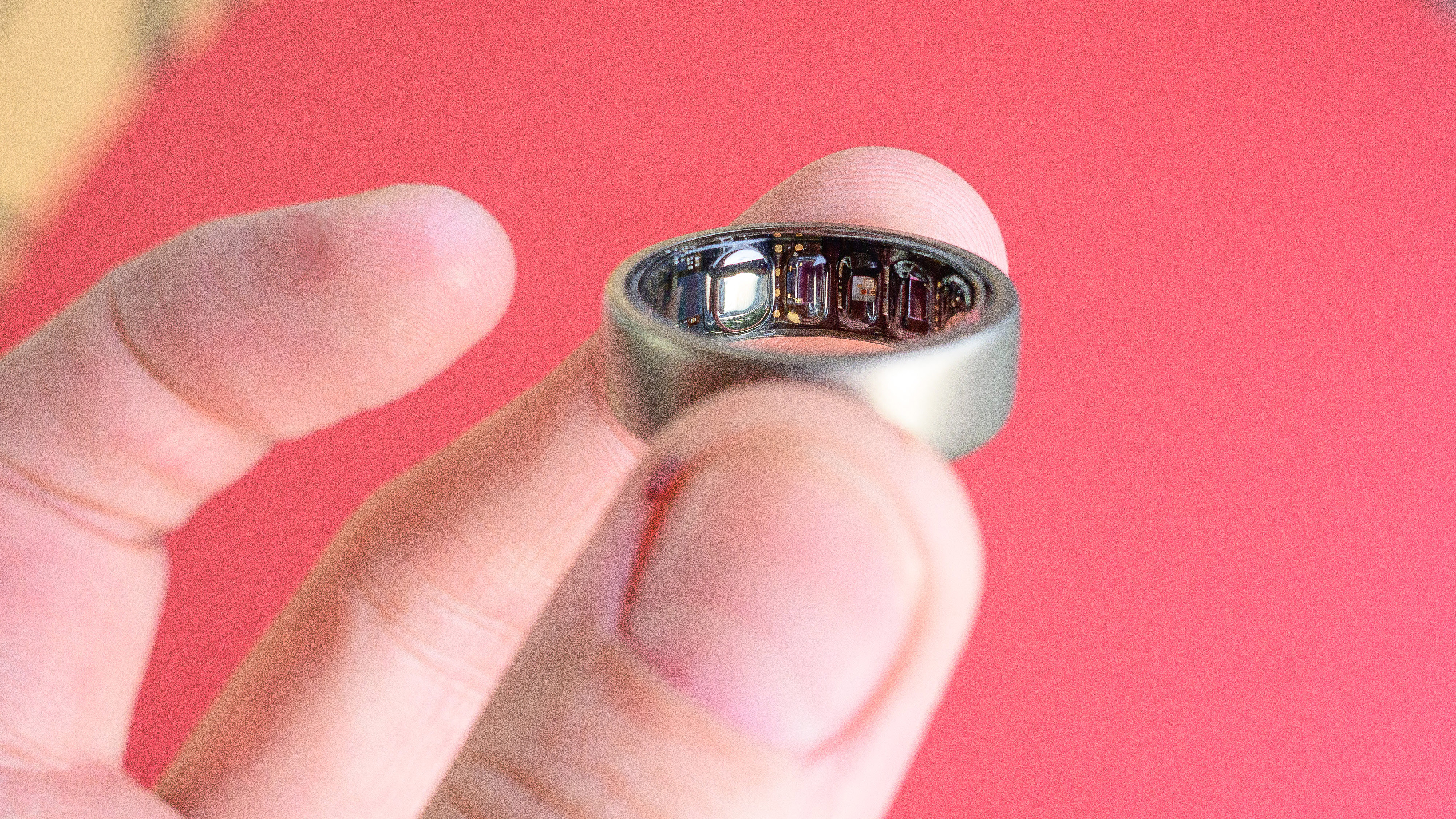 טבעת Amazfit Helio מוחזקת באצבע של משתמש ומראה את החיישנים בחלק הפנימי של הטבעת