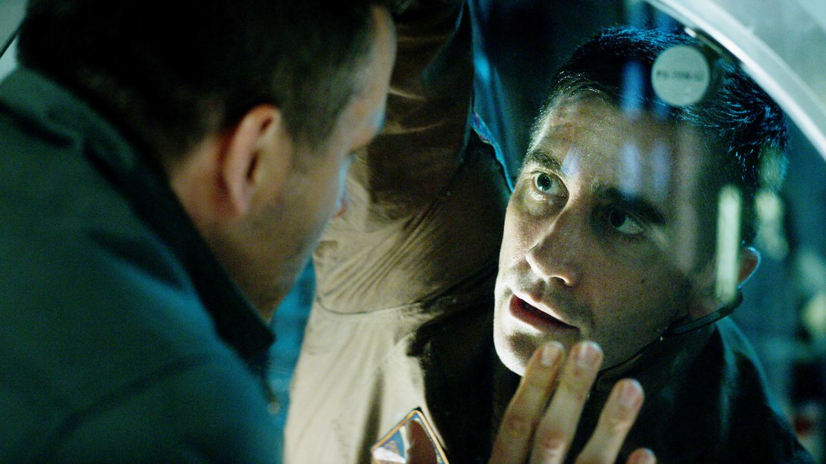 Jake Gyllenhaal peering through a window in