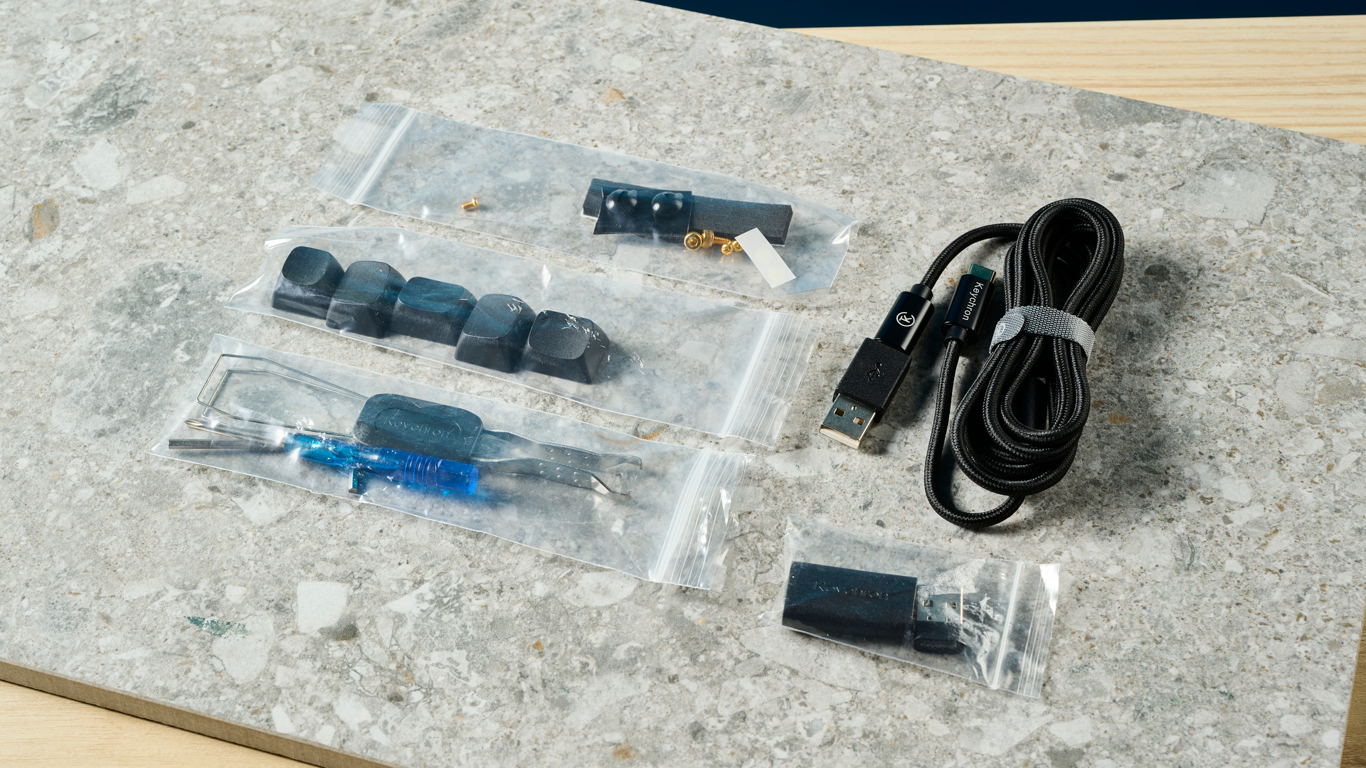תמונה של כלים ואביזרים של Keychron Q3 Max על משטח אבן