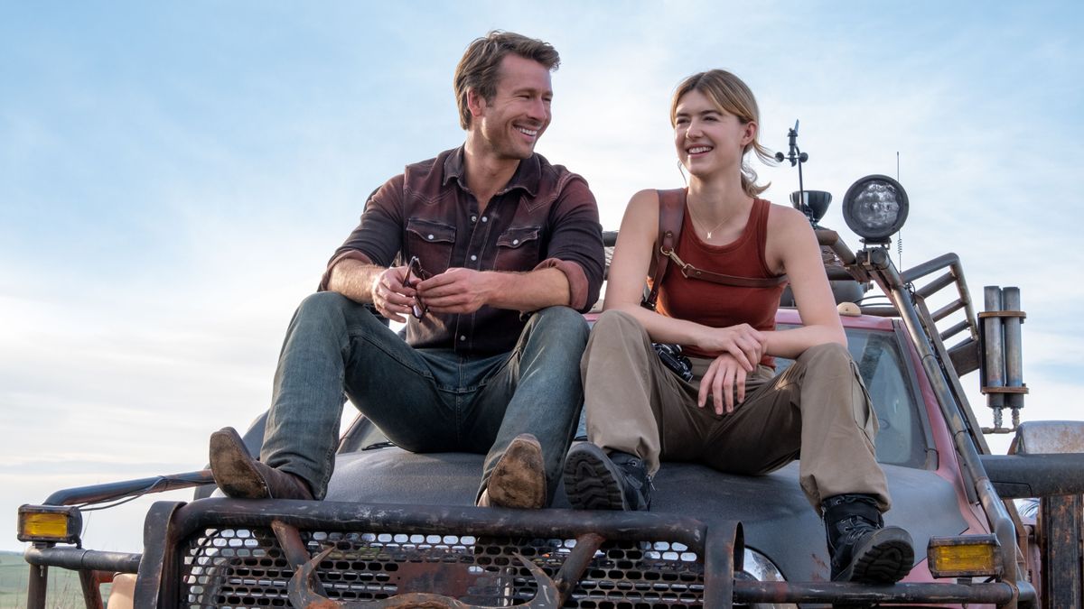 Glen Powell and Daisy Edgar-Jones sit on the hood of a truck in
