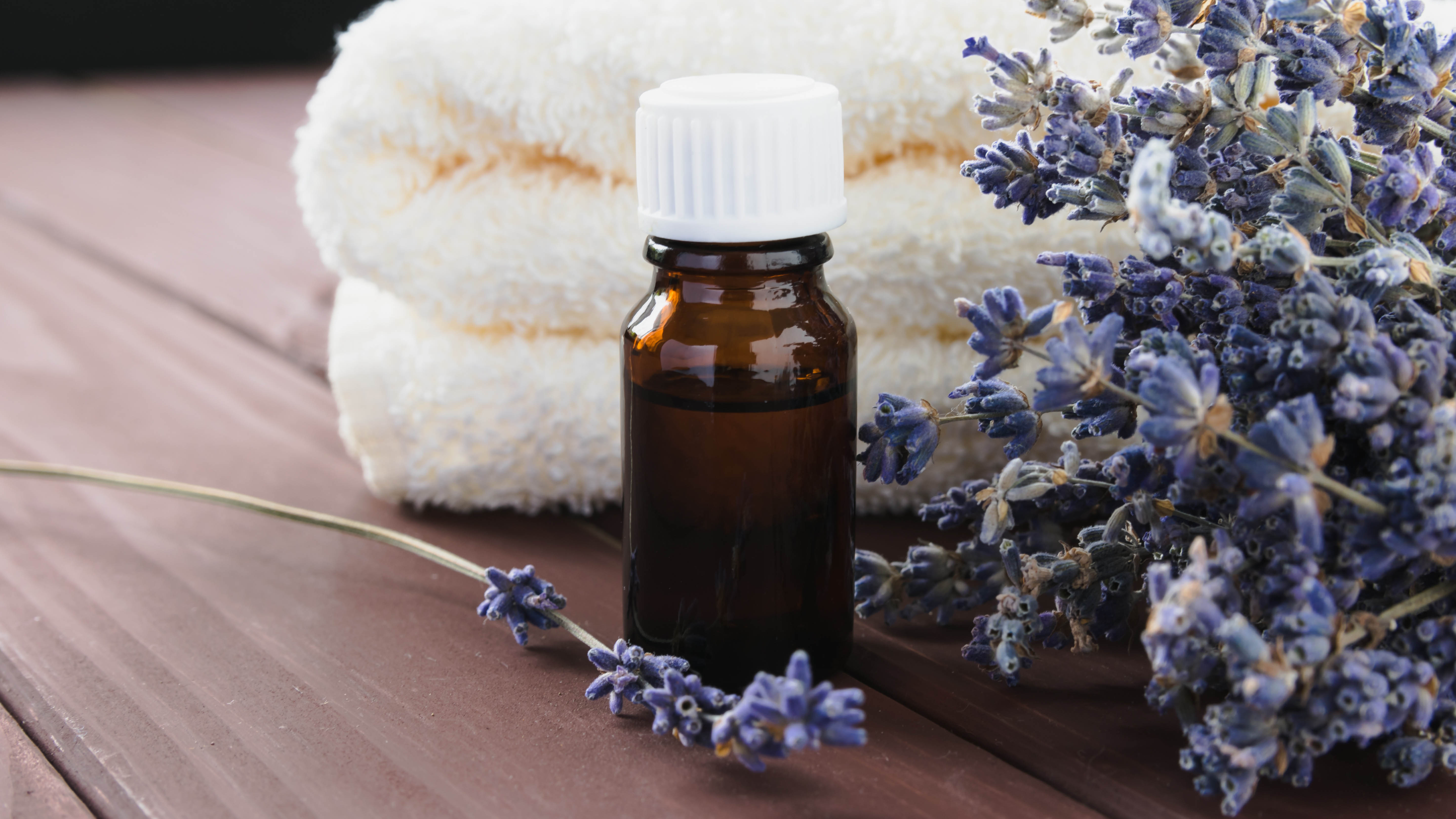 בקבוק שמן לבנדר ליד מגבות