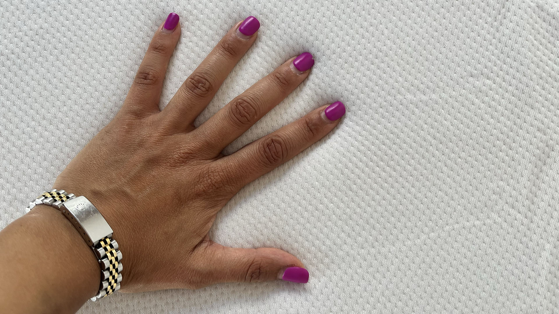 יד מונחת על כריכה של Tempur-Adapt Topper