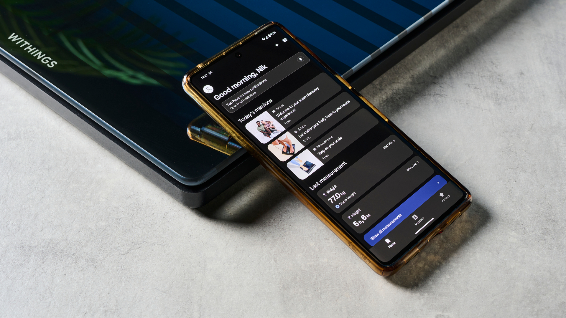 סמארטפון המציג את אפליקציית Withings מונחת על גבי מאזני Withings Body Scan
