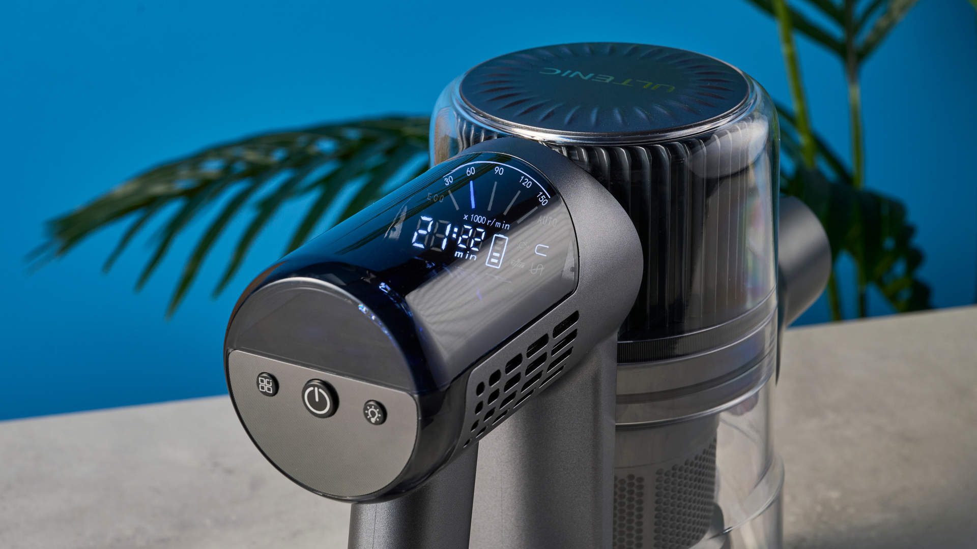 שואב אבק מבריק במראה מודרני עם רכיבים אפורים בהירים על שטיח מול רקע כחול