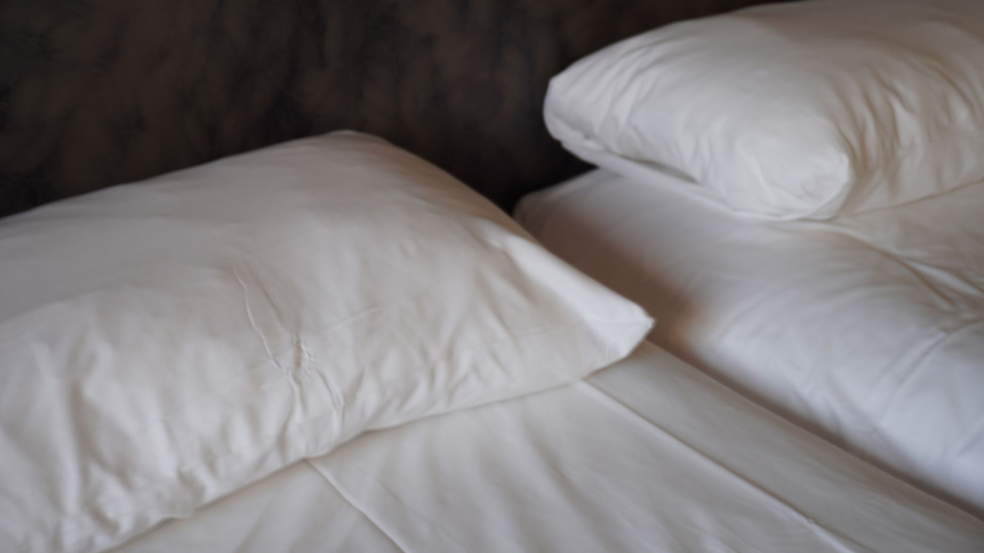 תקריב של מזרון קינג מפוצל לבוש בסדינים וכריות לבנים