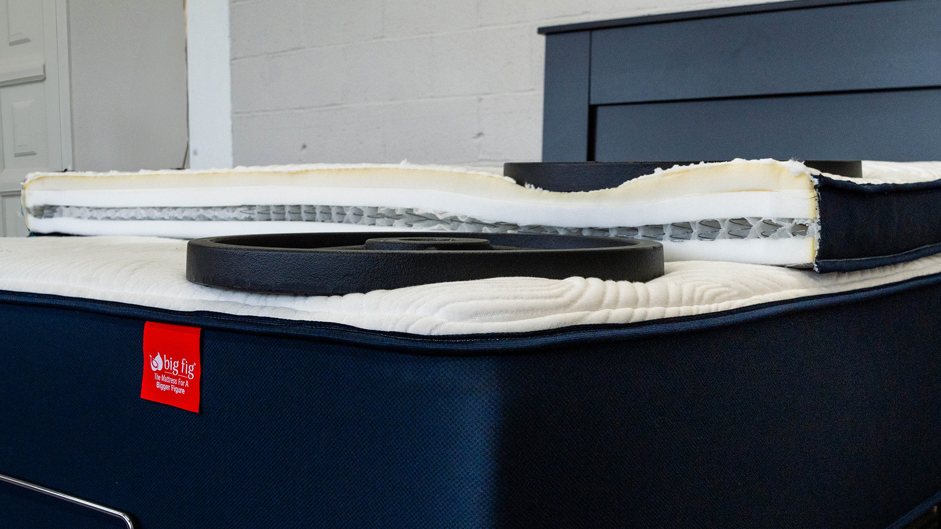 ה-Big Fig Premium Plush Micro-Coil Topper למעלה אם מזרן Big Fig, חתוך לשניים כדי להראות את שכבות הקצף הצפופות והמיקרו-סלילים בפנים