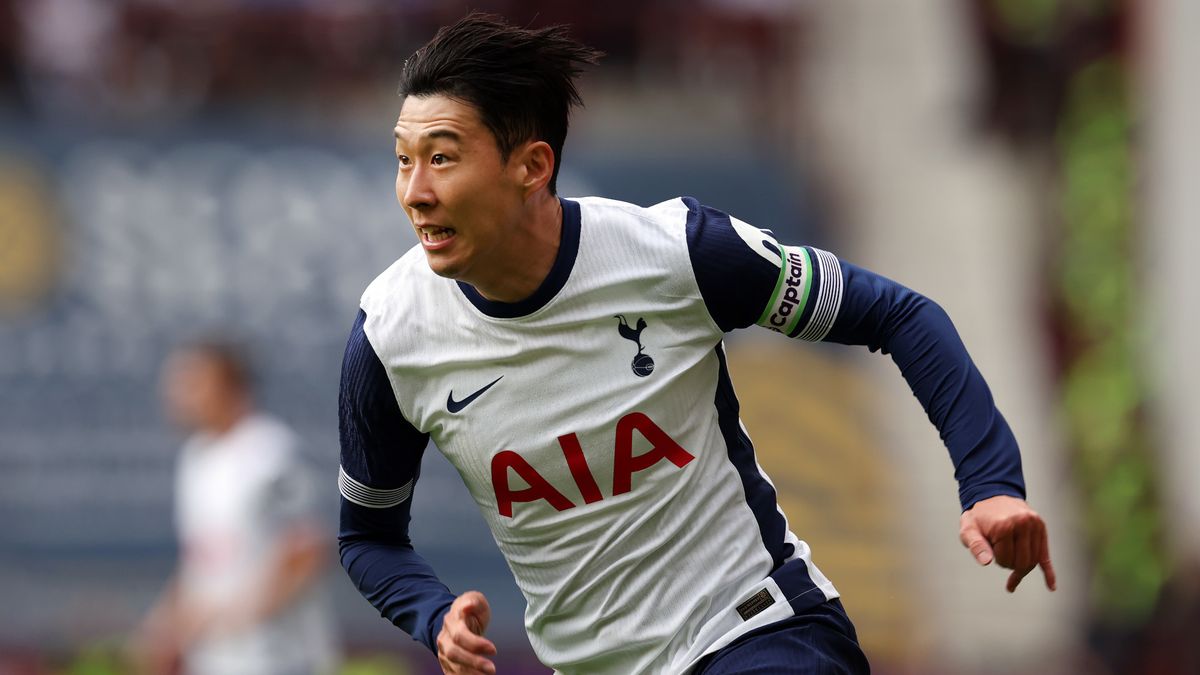 Son Heung-Min running at high speed in the Tottenham navy blue and white strip.