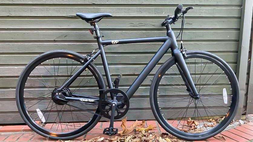 Ride1Up Roadster V2 חונה נגד בניין