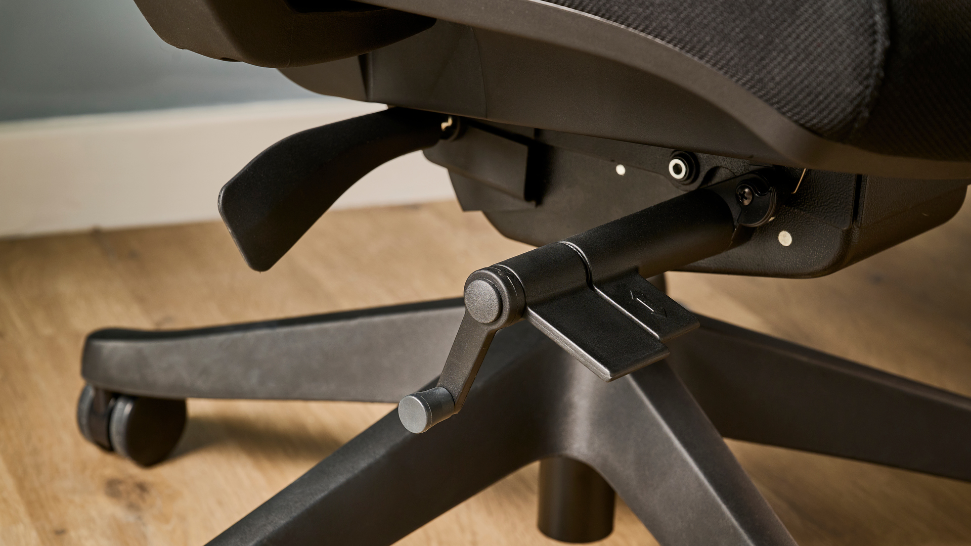 תמונה של ה-Autonomous ErgoChair Pro מול קיר כחול-אפור במשרד.