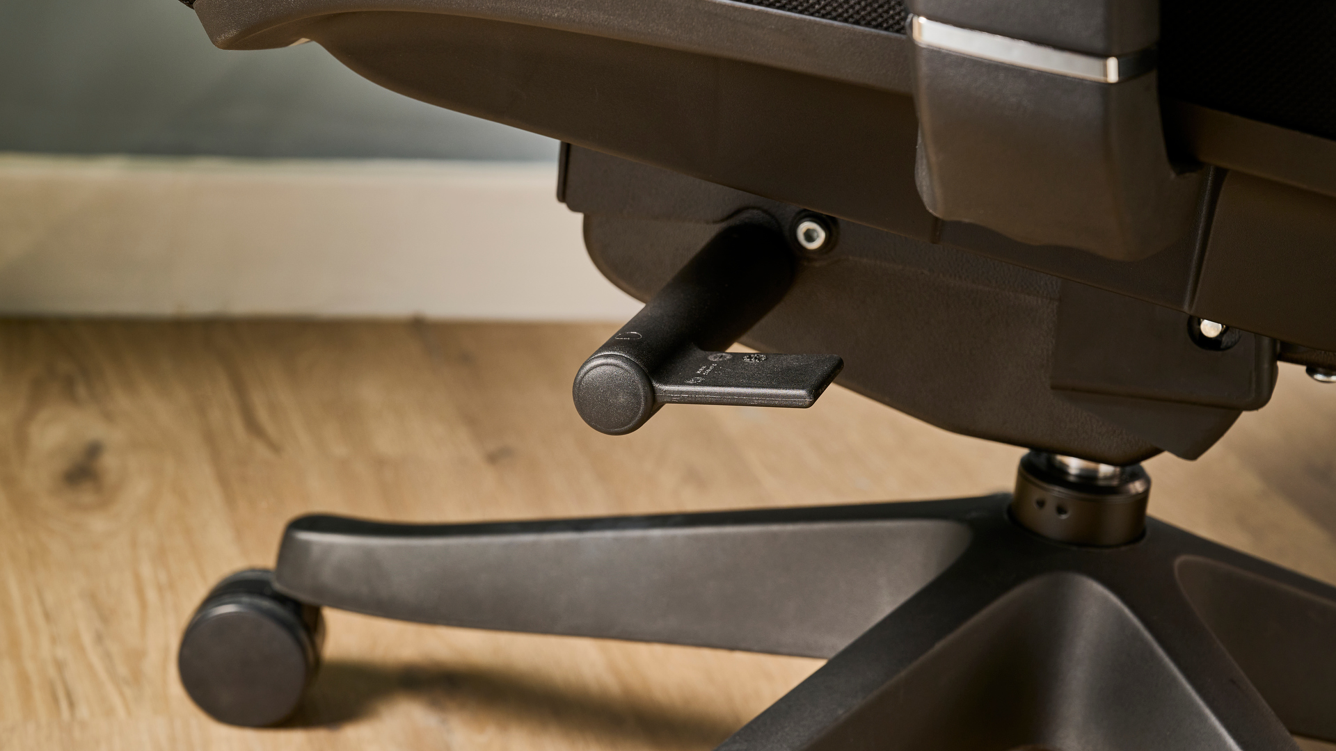 תמונה של ה-Autonomous ErgoChair Pro מול קיר כחול-אפור במשרד.