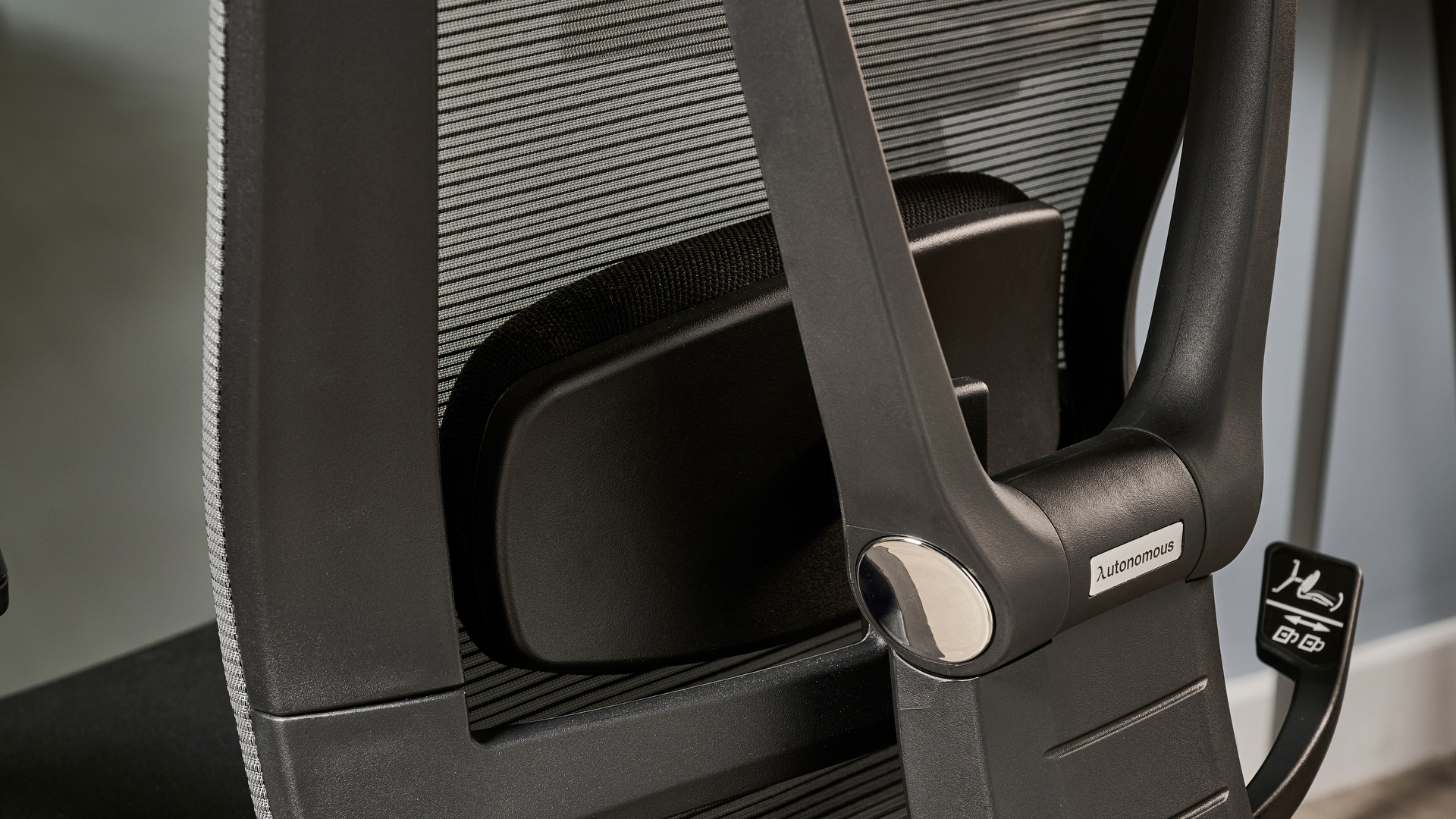 תמונה של ה-Autonomous ErgoChair Pro מול קיר כחול-אפור במשרד.