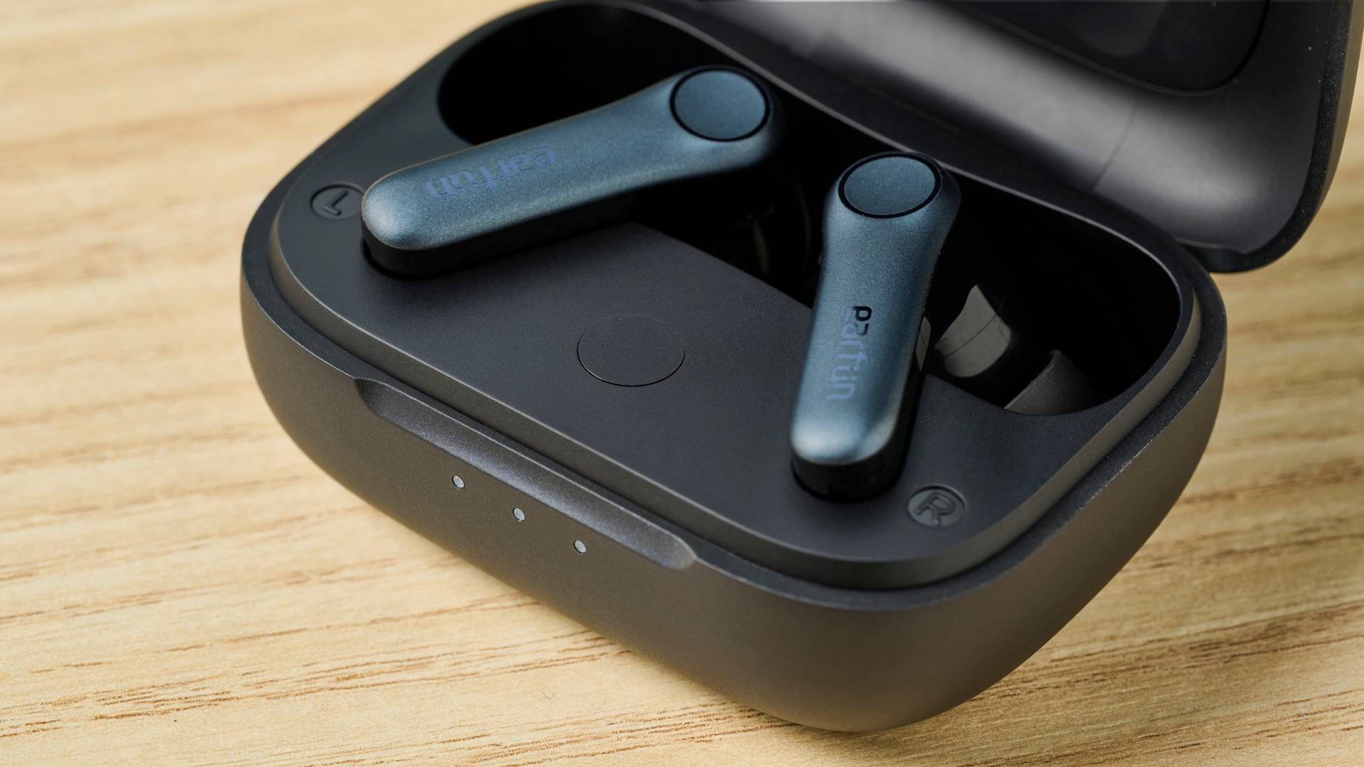 תמונה של אוזניות EarFun Air Pro 4 בתוך הנרתיק שלהן על משטח עץ