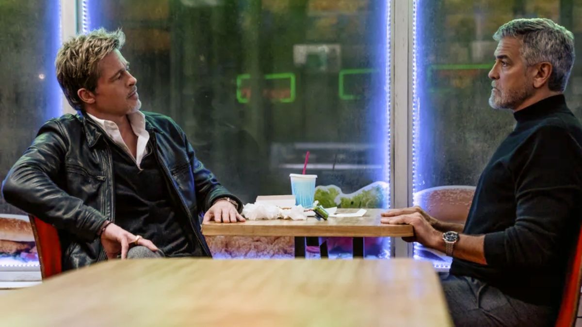 Brad Pitt and George Clooney sit across a diner table from one another in the Apple TV Plus original movie,