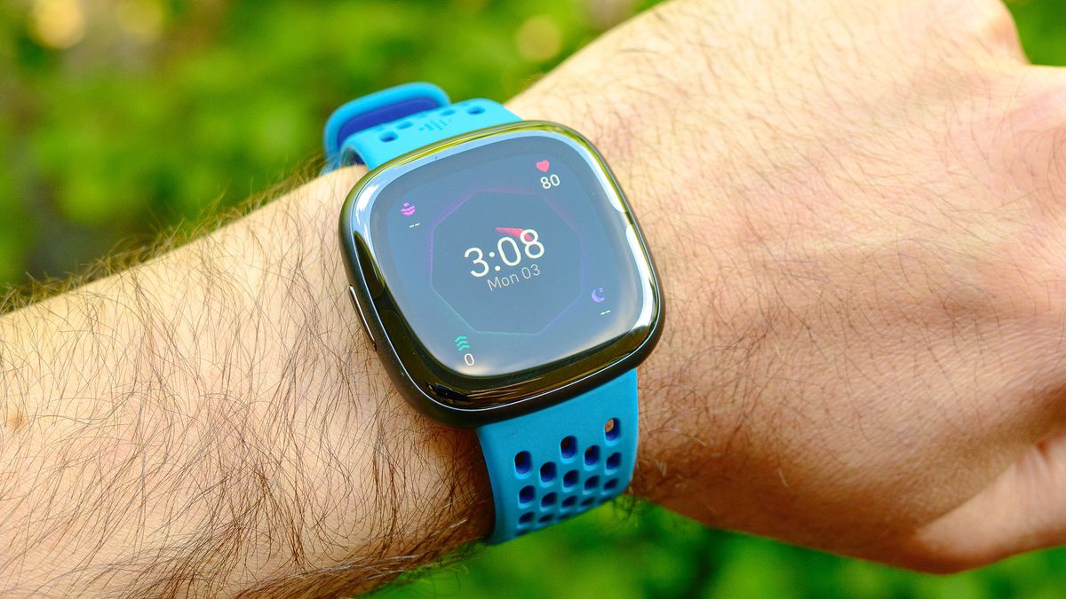 The Fitbit Sense 2 on a blue rubber strap, shown on a user