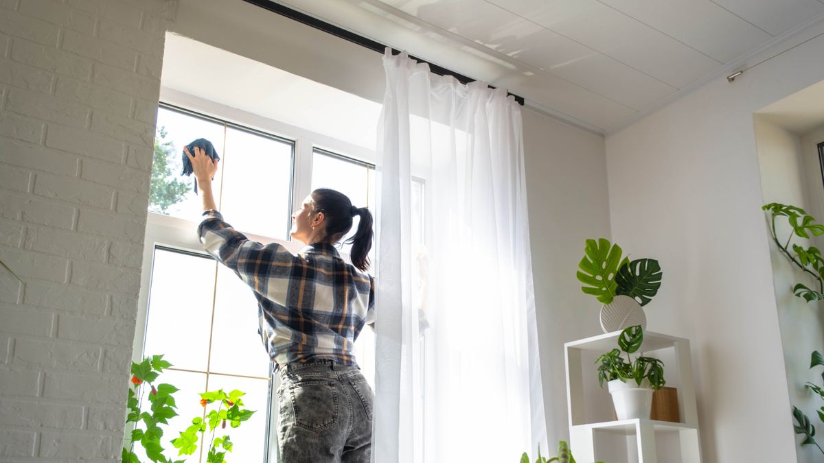 Woman cleaning window on a sunny day