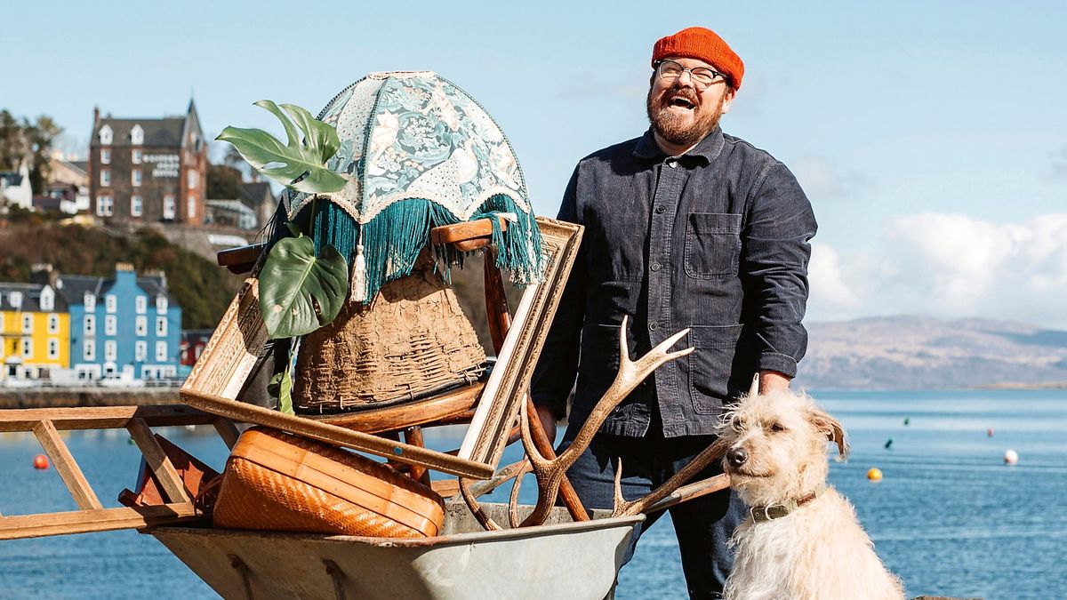 Banjo Beale, wearing red woolly hat and workmanlike denim jacket, carries a wheelbarrow filled with bric-a-brac alongside his faithful dog in BBC's Designing the Hebrides season 2