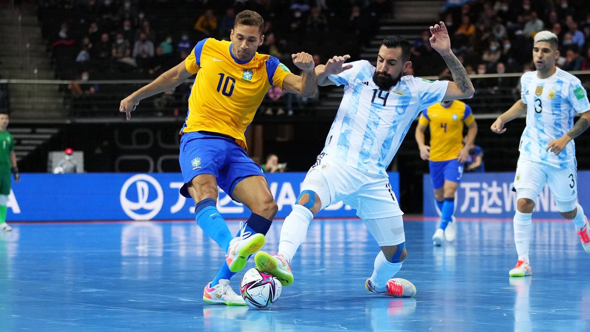Pito of Brazil (L), in a yellow and blue kit, battles for possession with Pablo Taborda of Argentina, in a blue and white striped kit, during a Futsal World Cup game.
