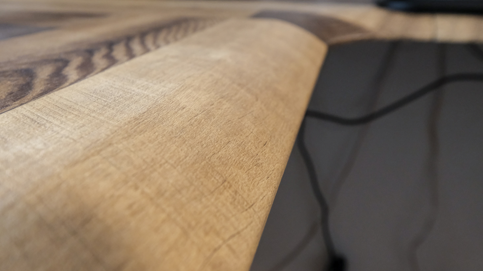 תקריב של הקצה המעוגל של שולחן העבודה העמיד החשמלי Vari L-Shape