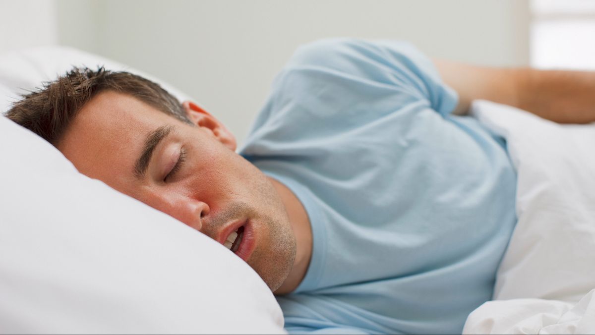 Man sleeping on his side with his mouth open snoring
