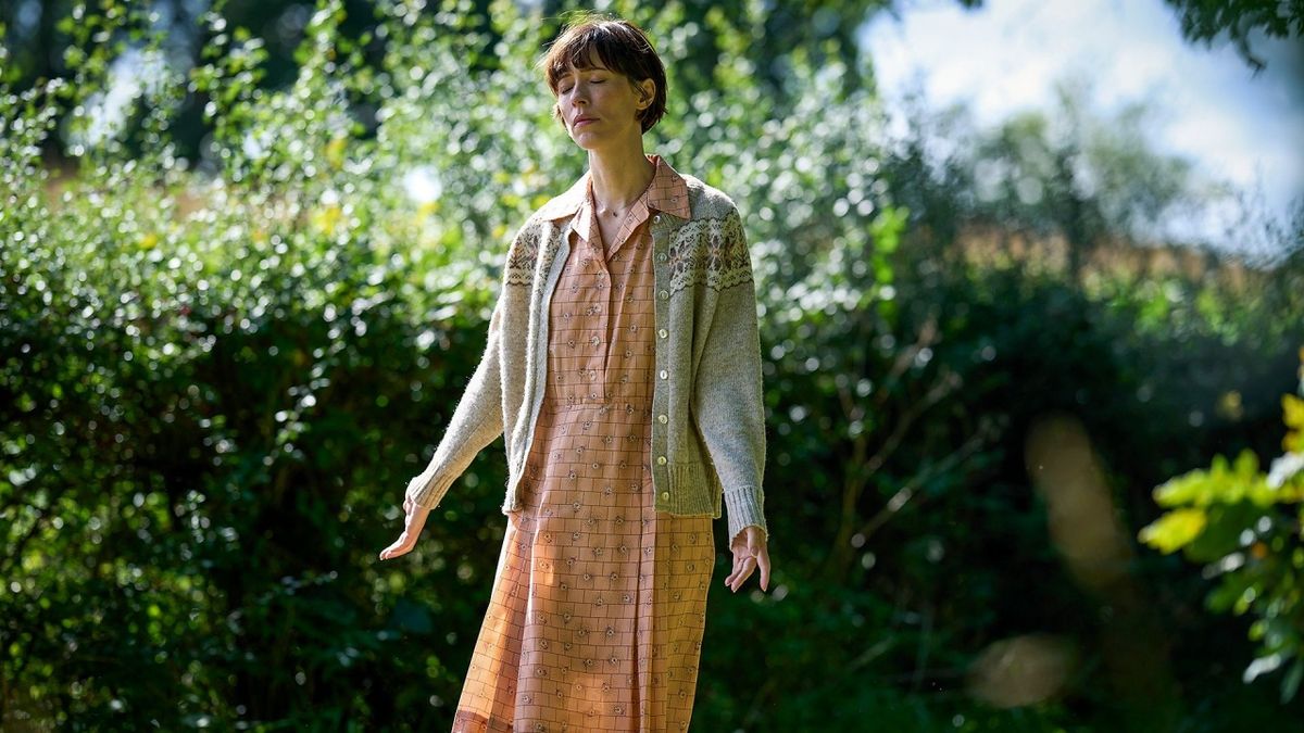 Claire (Rebecca Hall) stands peacfully in a sunlit grove in "The Listeners"