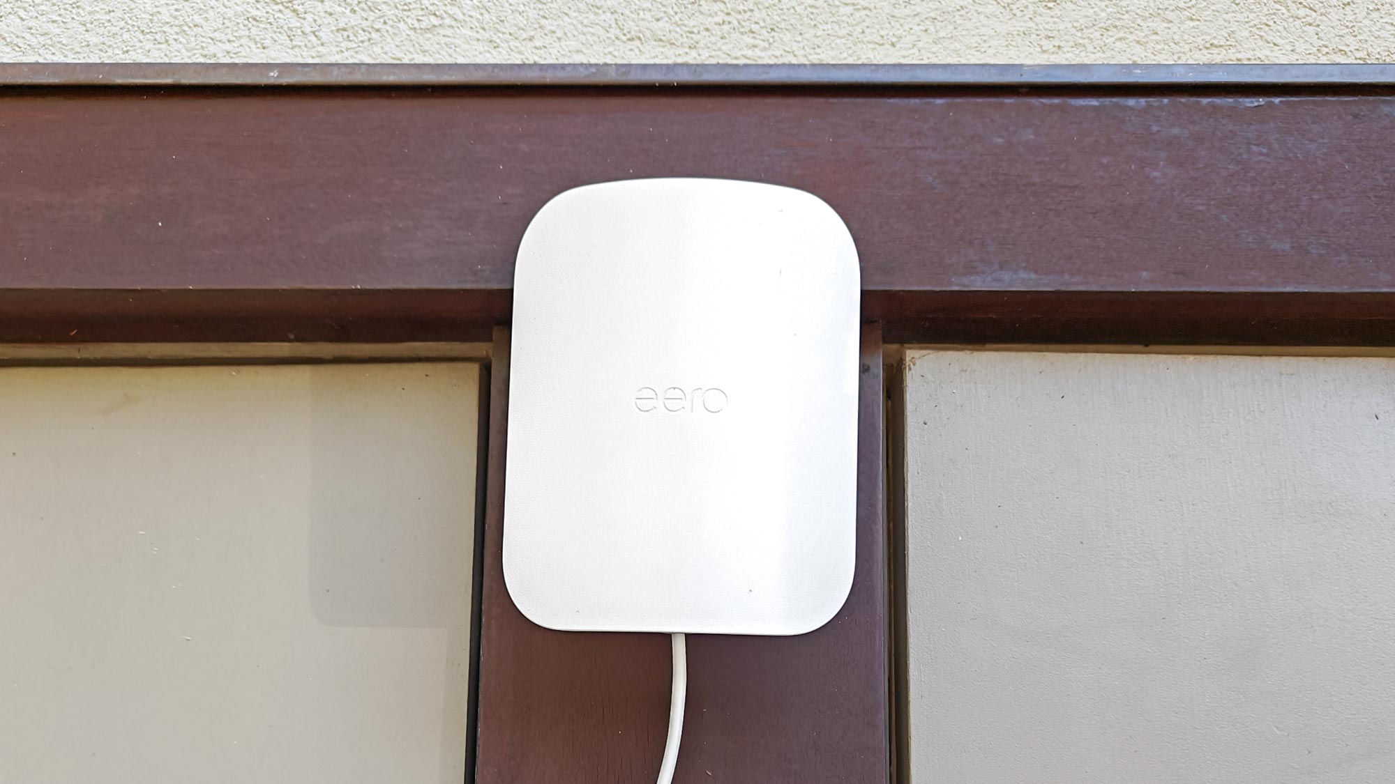מאריך Eero Outdoor 7 mesh המותקן על קיר חיצוני
