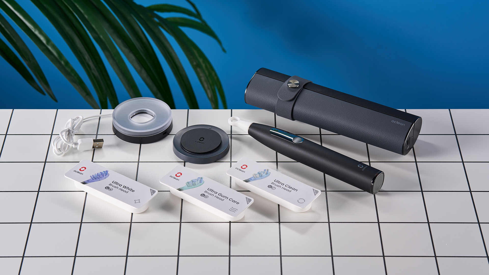 מברשת שיניים חשמלית שחורה עם מסך מגע קטן וראש מברשת שיניים כחול ומעמד טעינה מרובע